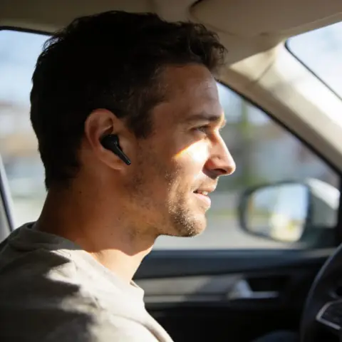 Außendienstmitarbeiter mit Headset im Auto